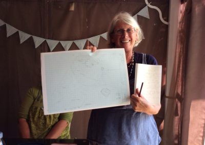 Learning permaculture - student holding up her design