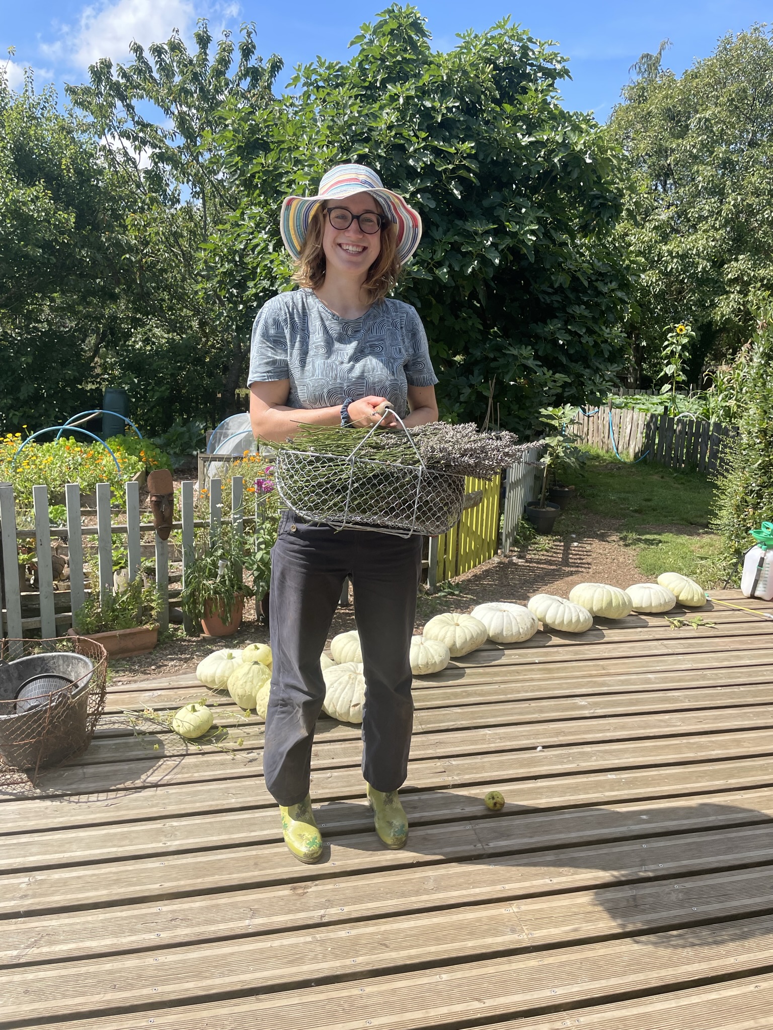 Volunteer holding a basket of vegetables that she has harvested from the garden